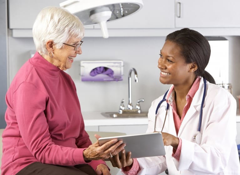 Older woman and a doctor smiling at each other