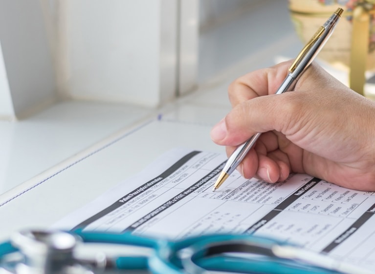 hand holding a pen filling out a form
