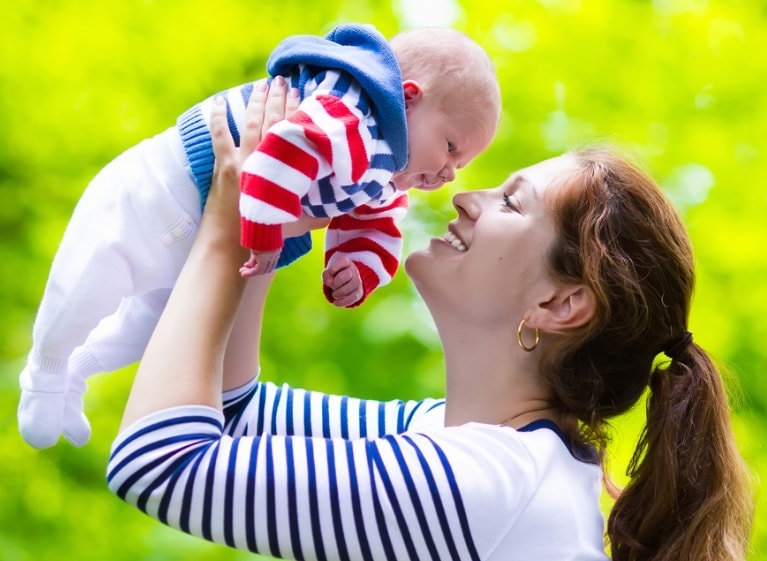 woman holding up a baby