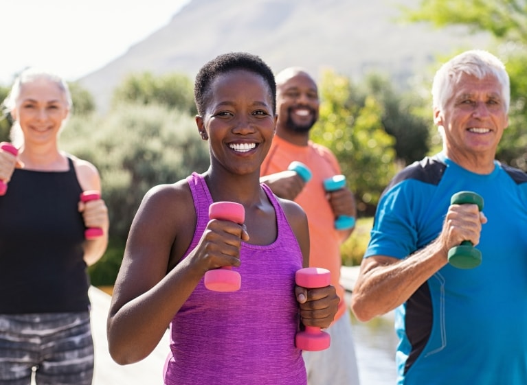 four adults holding weights