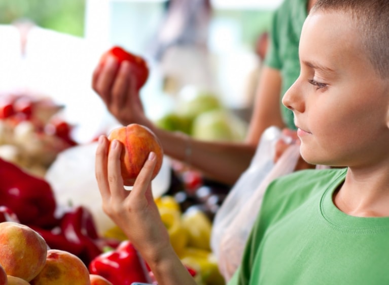 Boy holding and looking at an apple