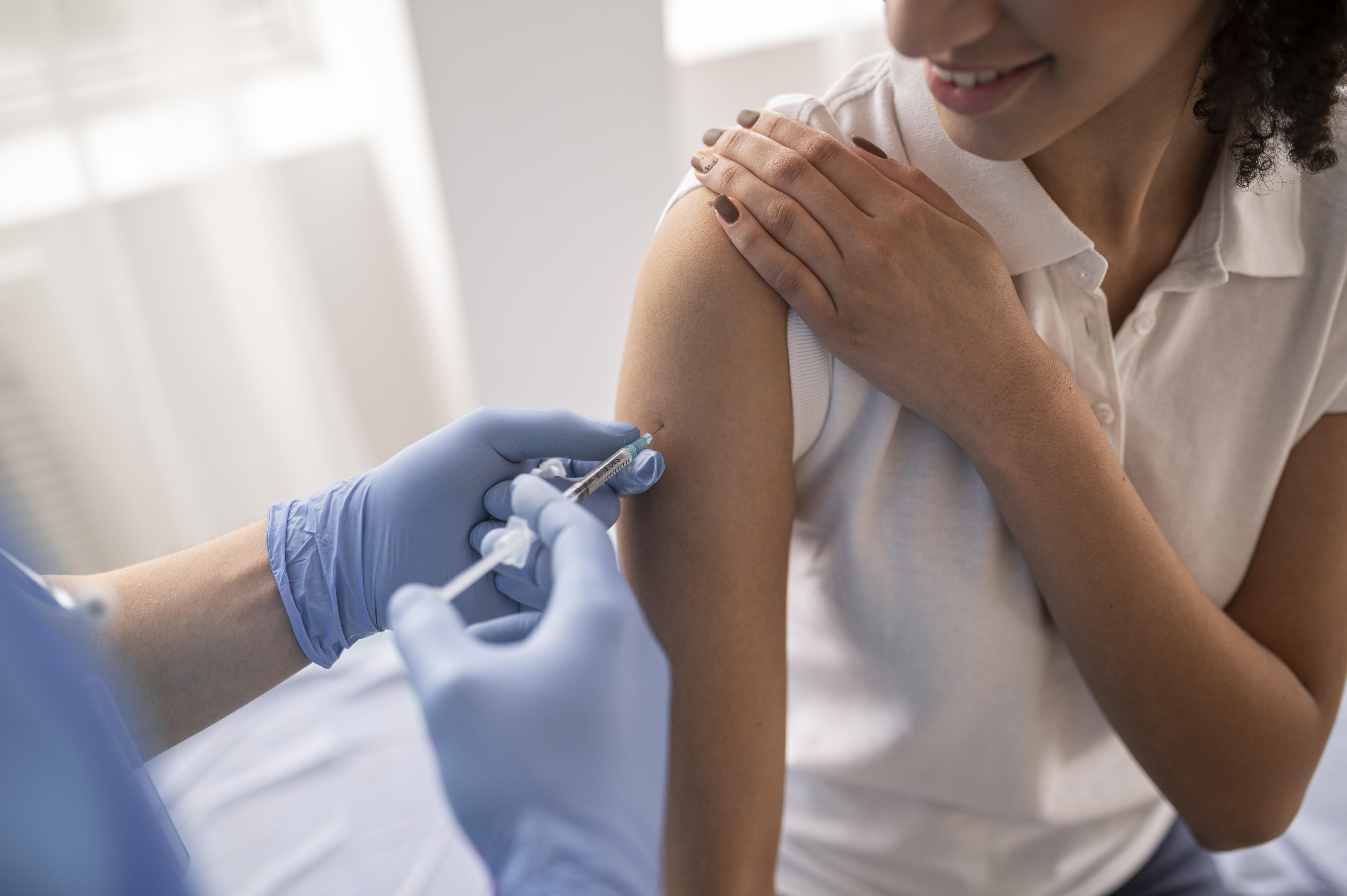 Person's arm being injected with a vaccination.