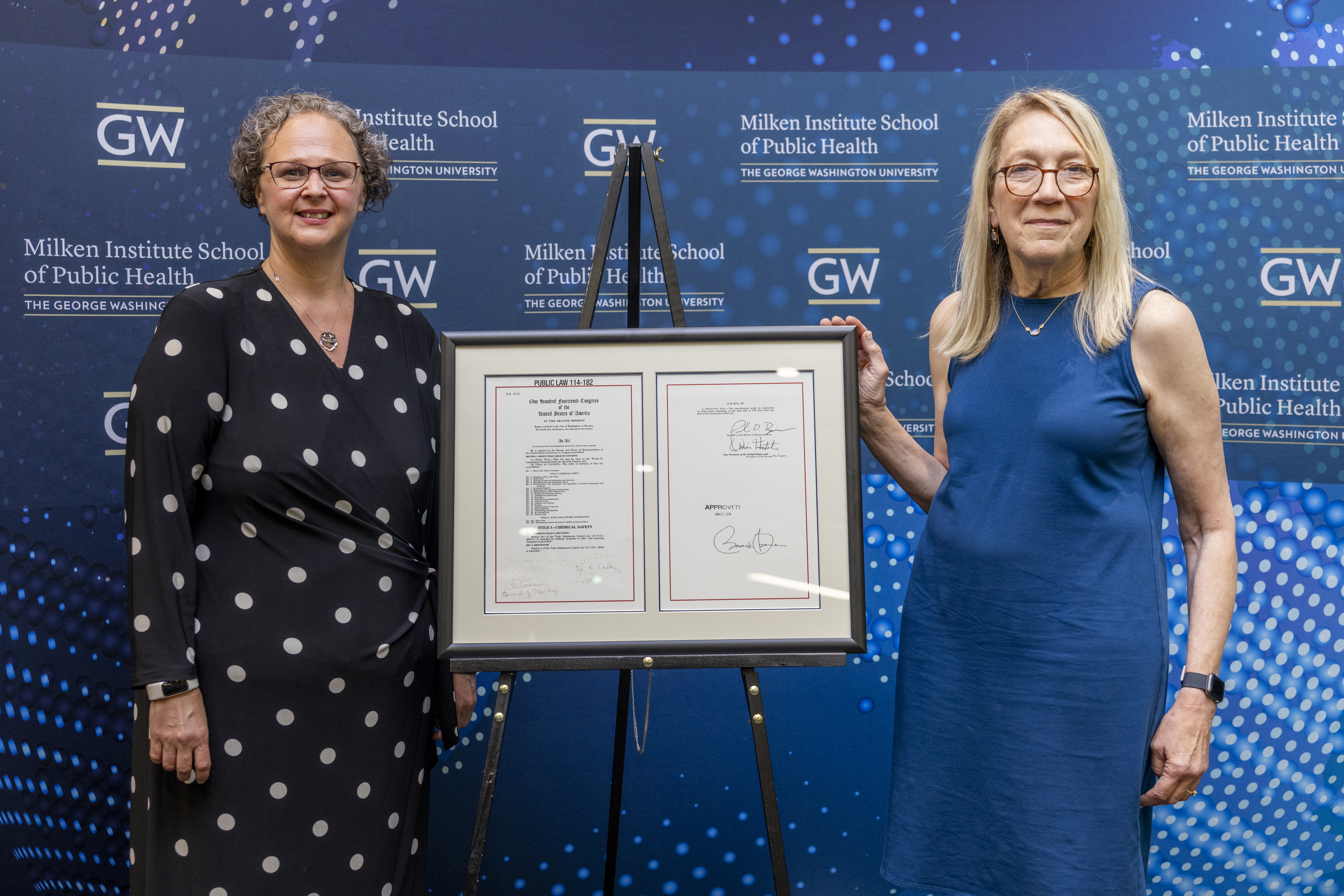 Associate Dean Robin Delaloye and Dean Goldman standing beside the enrolled legistation.