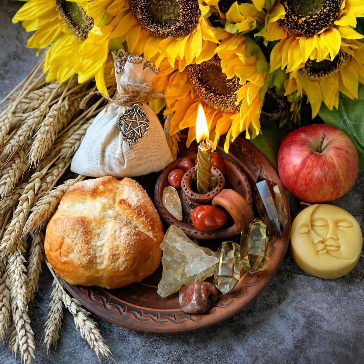 Lammas Bread, Candles, Apples, and sunflowers places on a dish
