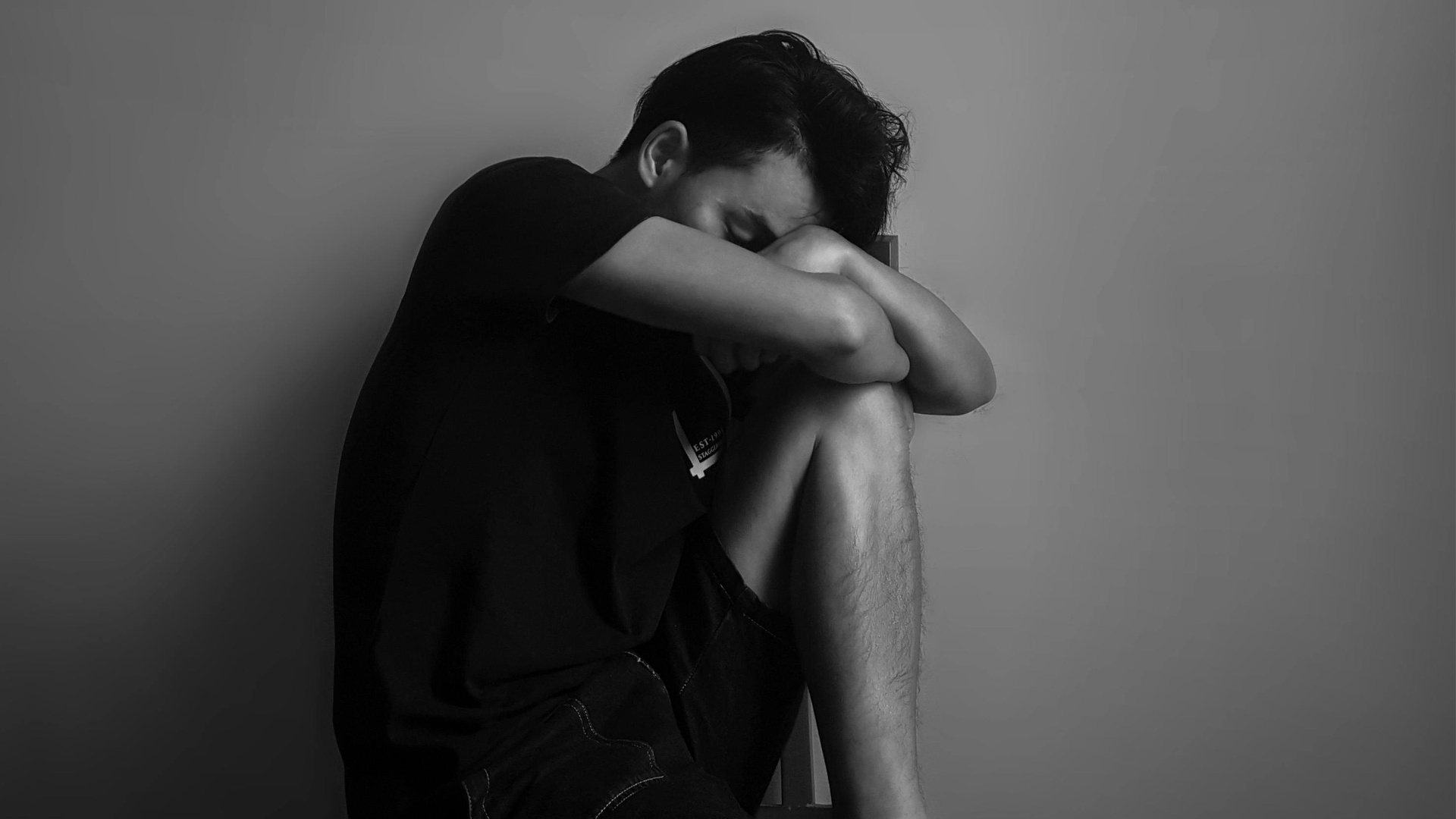 Man sitting down looking very sad.