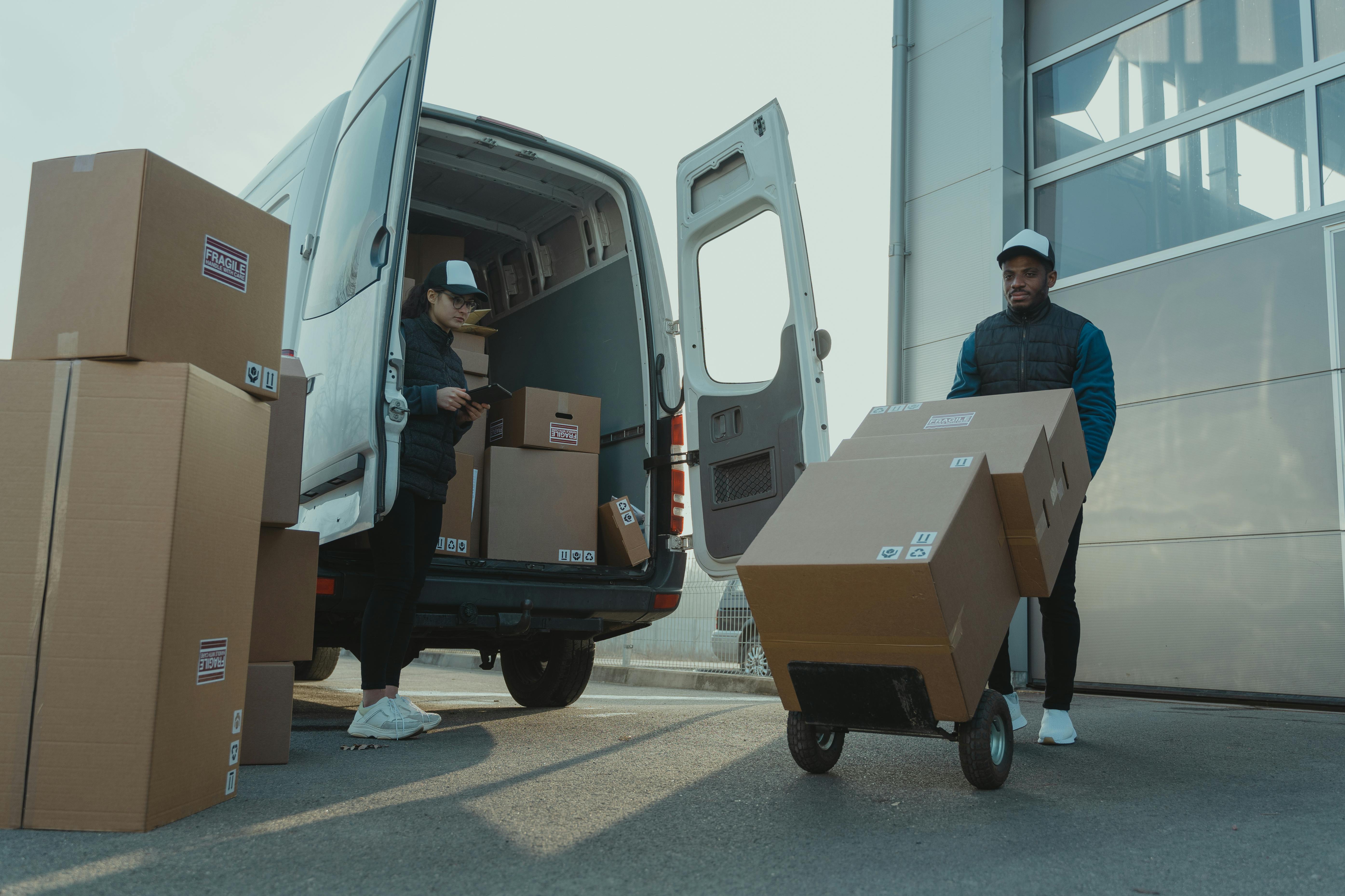 Two workers unloading boxes from a van.