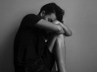 Man sitting down looking very sad.