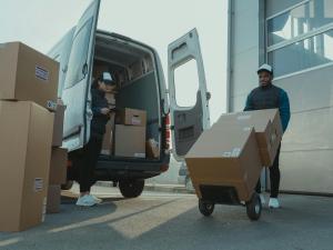 Two workers unloading boxes from a van.