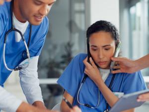 Nurse surrounded by other nurses looking very busy