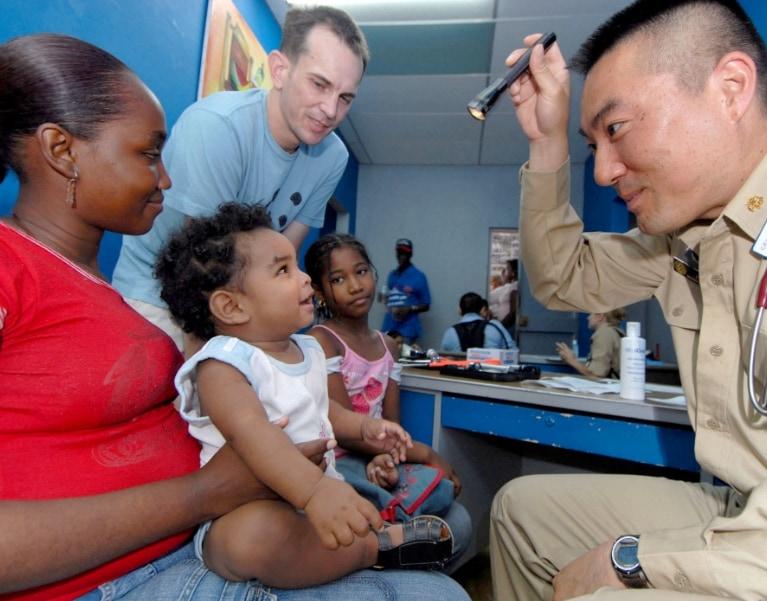 Military doctor treating a child