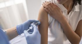 Person's arm being injected with a vaccination.