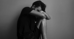 Man sitting down looking very sad.