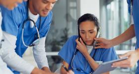 Nurse surrounded by other nurses looking very busy